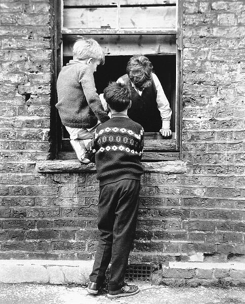 Boys at a boarded up window, Balham, SW London