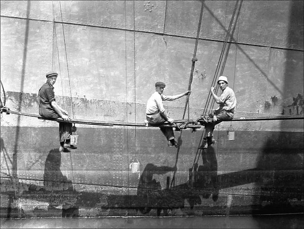 Men painting the side of a large boat