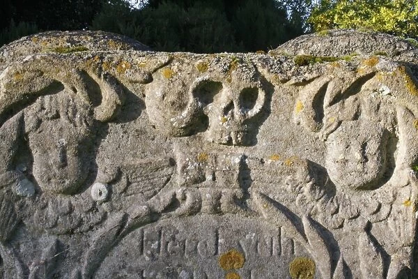 Skull carved on headstone in church graveyard, St. Andrew's Church, Wickham Skeith, Suffolk, England, october