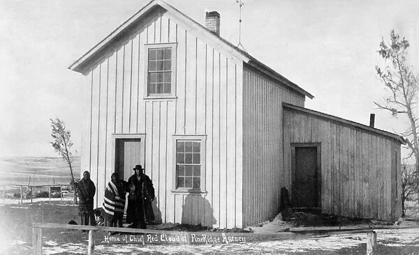 PINE RIDGE AGENCY, c1891. Three Native Americans standing outside the home of Chief