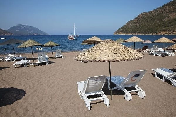 Turkey, sun loungers and palapas on Adrasan beach, near Kemer