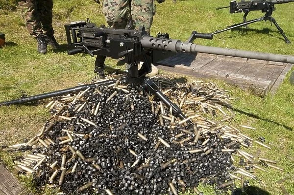 A. 50 Caliber Browning Machine Gun with a pile of spent cases and links