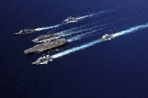 The Abraham Lincoln Carrier Strike Group ships cruise in formation in the Pacific Ocean
