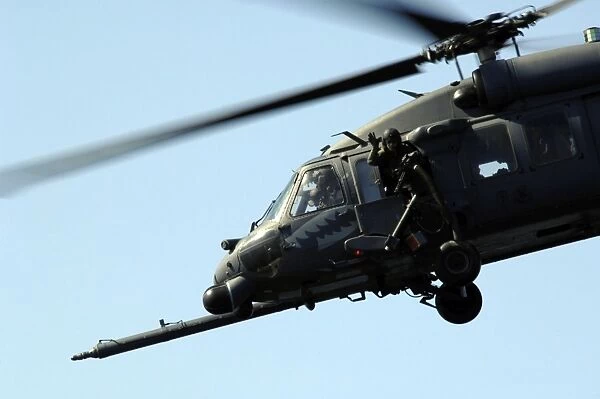 An aerial gunner waves goodbye from an HH-60G Pave Hawk