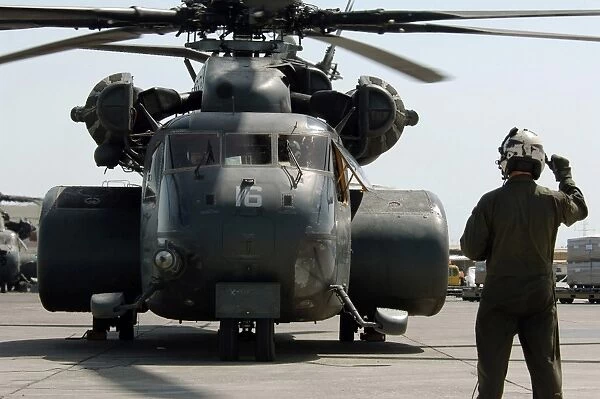 Air crewman gives the engine start up signal to pilots aboard a MH-53E Sea Dragon