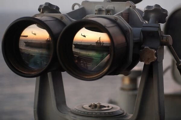 Aircraft carrier USS Dwight D. Eisenhower is reflected in a set of Big Eyes binoculars