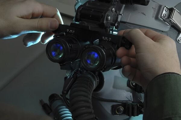Airman adjusts the eyespan on a pair of night vision goggles