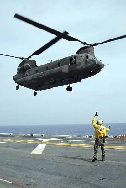 Airman directs an Army CH-47 Chinook helicopter on the flight deck