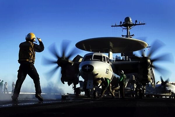 An Airman guides an E-2C Hawkeye