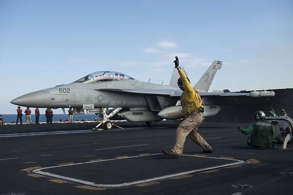 Airman signals an EA-18G Growler for launch