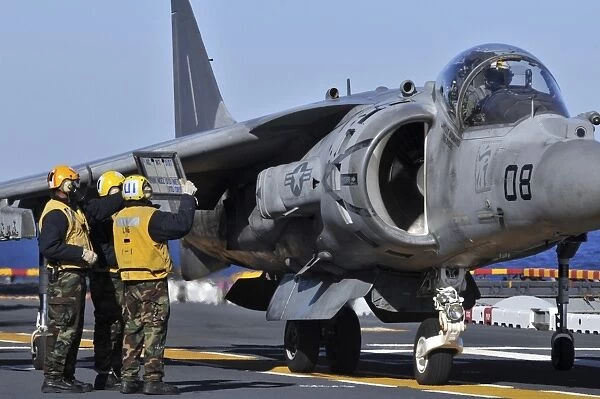 Airmen show flight information to an AV-8B Harrier pilot