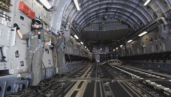 Airmen prepare to drop a practice bundle from a C-17 Globemaster III
