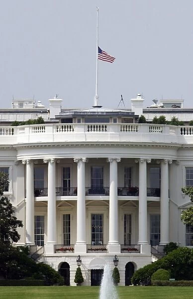 The American flag flies at half-staff atop the White House