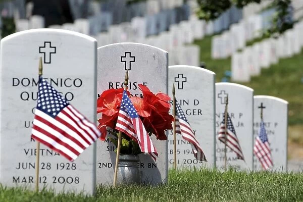 American flags placed in the front of headstones at Arlington National Cemetery