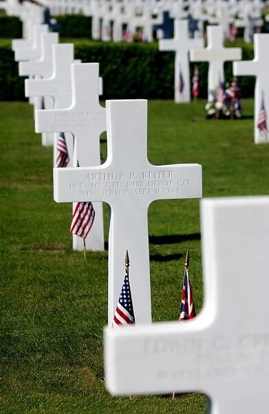 American flags rest in front of headstones at Madingley American Cemetery