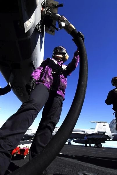 Aviation Boatswains Mate Airman fuels an aircraft