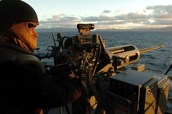 Aviation Ordnanceman mans a MK-38 25mm machine gun aboard USS Peleliu
