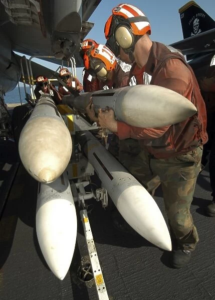 Aviation Ordnancemen load AIM-7 Sparrow air-to-air missiles on an F-14B Tomcat