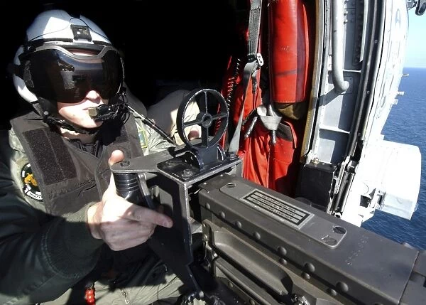 Aviation Warfare Systems Operator mans a. 50 caliber machine gun