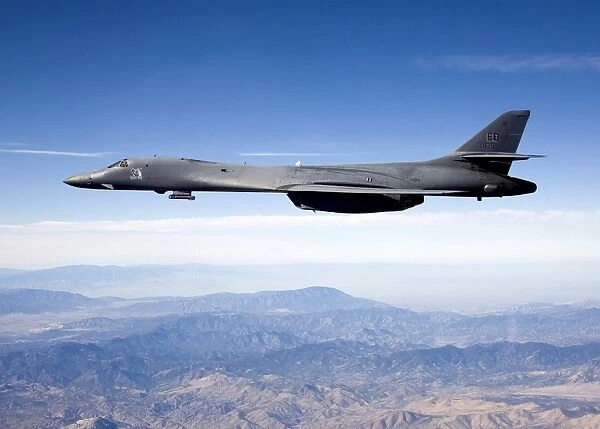 A B-1B Lancer carries the Sniper pod on its belly as it flies through the sky