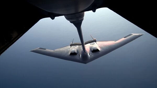 A B-2 Spirit bomber conducts a refueling with a KC-10 Extender