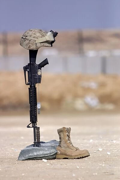 Boots, rifle, dog tags, and protective helmet stand in solitude to honor fallen soldiers