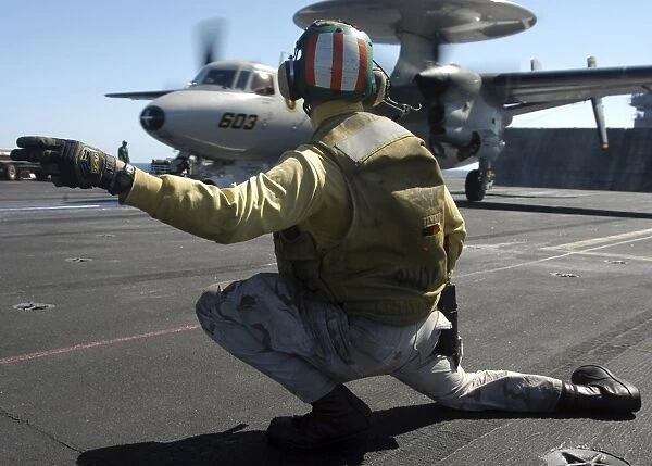 A catapult shooter signals the launch of an E-2C Hawkeye