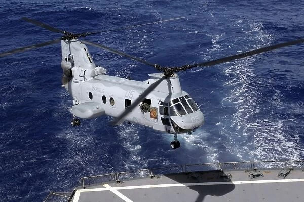A CH-46 Sea Knight helicopter lands on the deck of the USS Pecos