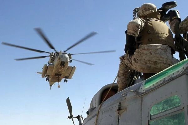 A CH-53 Super Stallion helicopter moves into position to externally lift a UH-1N
