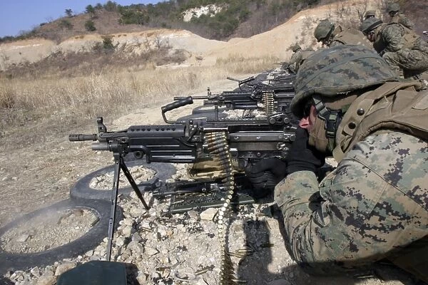 A corpsman fires an M249 Squad Automatic Weapon