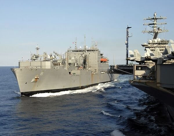Dry cargo and ammunition ship USNS Wally Schirra transits alongside aircraft carrier