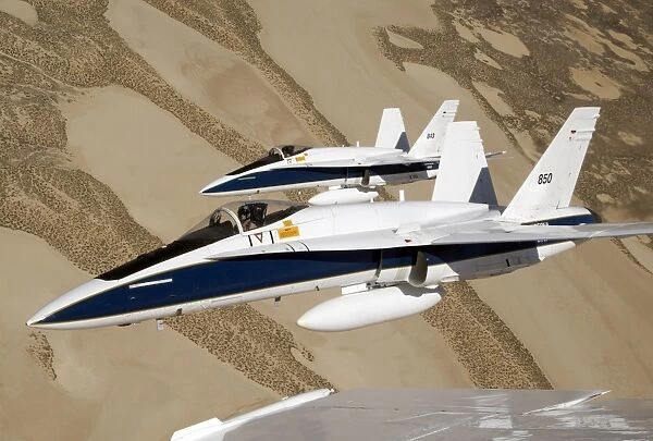 Two Dryden F  /  A-18s fly in tight formation over the desert