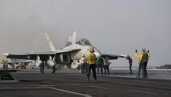 An EA-18G Growler is guided into catapult aboard USS George H. W. Bush
