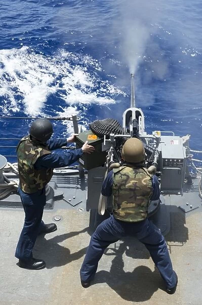 Electronics Technician fires a 25mm machine gun aboard USS Preble