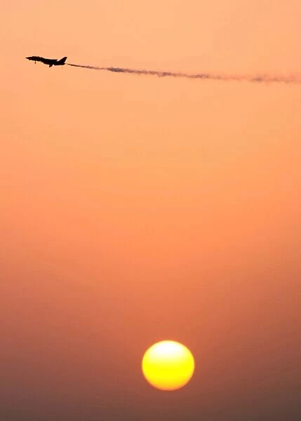 An F-14D Tomcat dumps fuel prior to a sunset landing