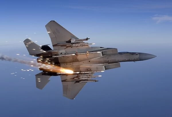An F-15 Eagle releases a flare while breaking hard to the left