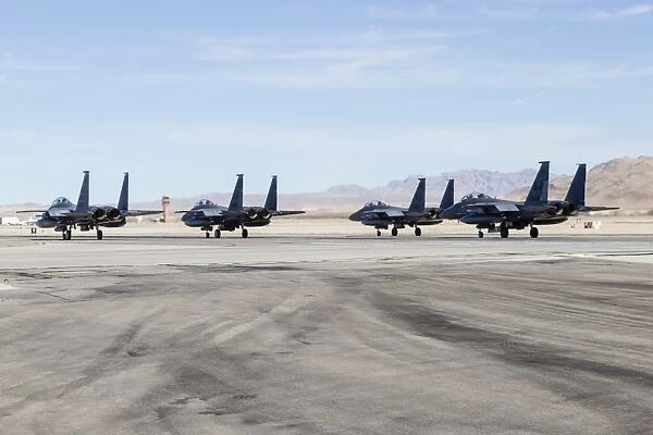 Four F-15E Strike Eagle fighters of the U. S. Air Force line up for takeoff