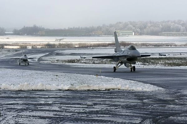 Two F-16 Fighting Falcons taxi down the runway in Florennes, Belgium