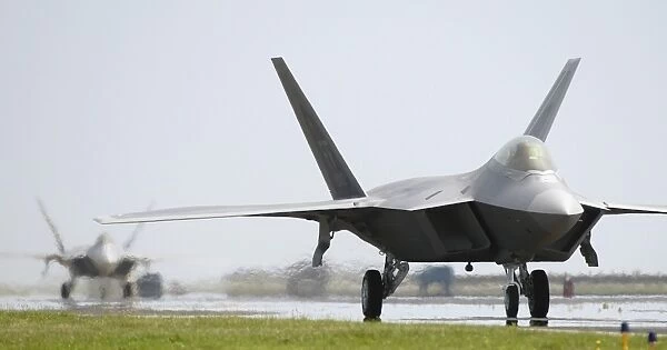Two F-22A Raptors taxi down the runway
