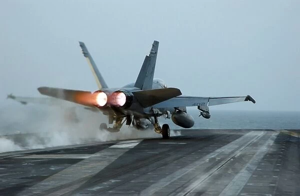 An F  /  A-18 Hornet launches from the flight deck aboard USS Theodore Roosevelt