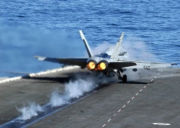 An F  /  A-18C Hornet launches from the flight deck aboard USS Abraham Linclon