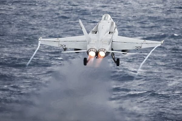 An F  /  A-18C Hornet launches from the flight deck of USS Harry S. Truman