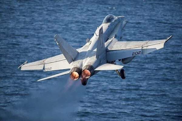 An F  /  A-18C Hornet launches from the flight deck of USS Harry S. Truman