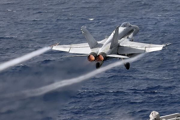 An F  /  A-18C Hornet launches off the flight deck of USS John C. Stennis