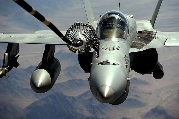 An F  /  A-18C Hornet receives fuel from the drogue of a KC-10 Extender