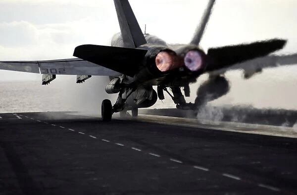 An F  /  A-18C Hornet rockets down the flight deck of USS Ronald Reagan