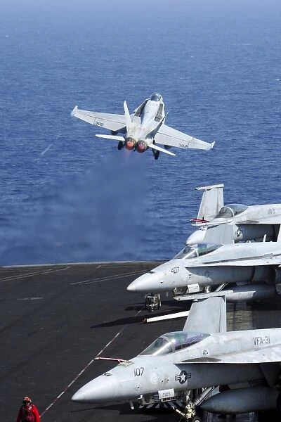 An F  /  A-18C Hornet takes off from the flight deck of USS George H. W. Bush