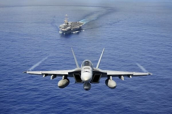 An F  /  A-18E Super Hornet flying above USS John C. Stennis