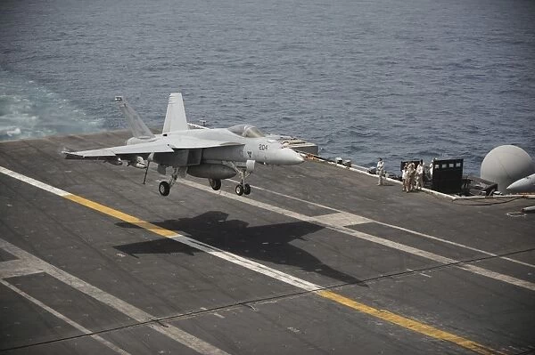 An F  /  A-18E Super Hornet lands aboard the aircraft carrier USS Nimitz