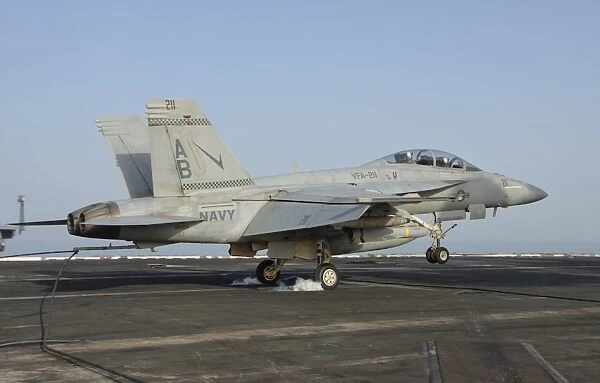 An F  /  A-18E Super Hornet makes an arrested landing aboard an aircraft carrier